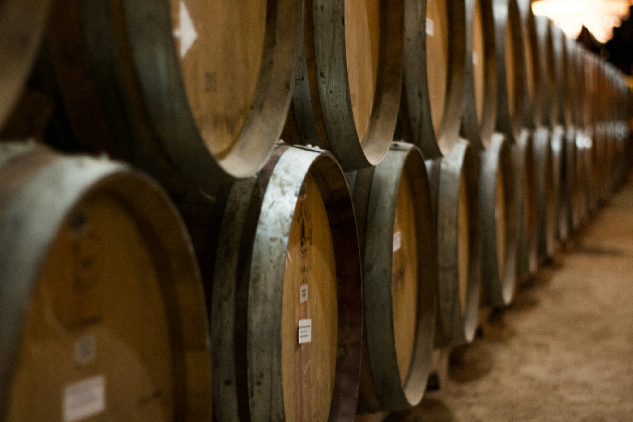 Two rows of barrels receding through a warehouse